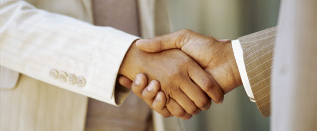 close-up of a businessman shaking hands with a businesswoman --- Image by © Royalty-Free/Corbis